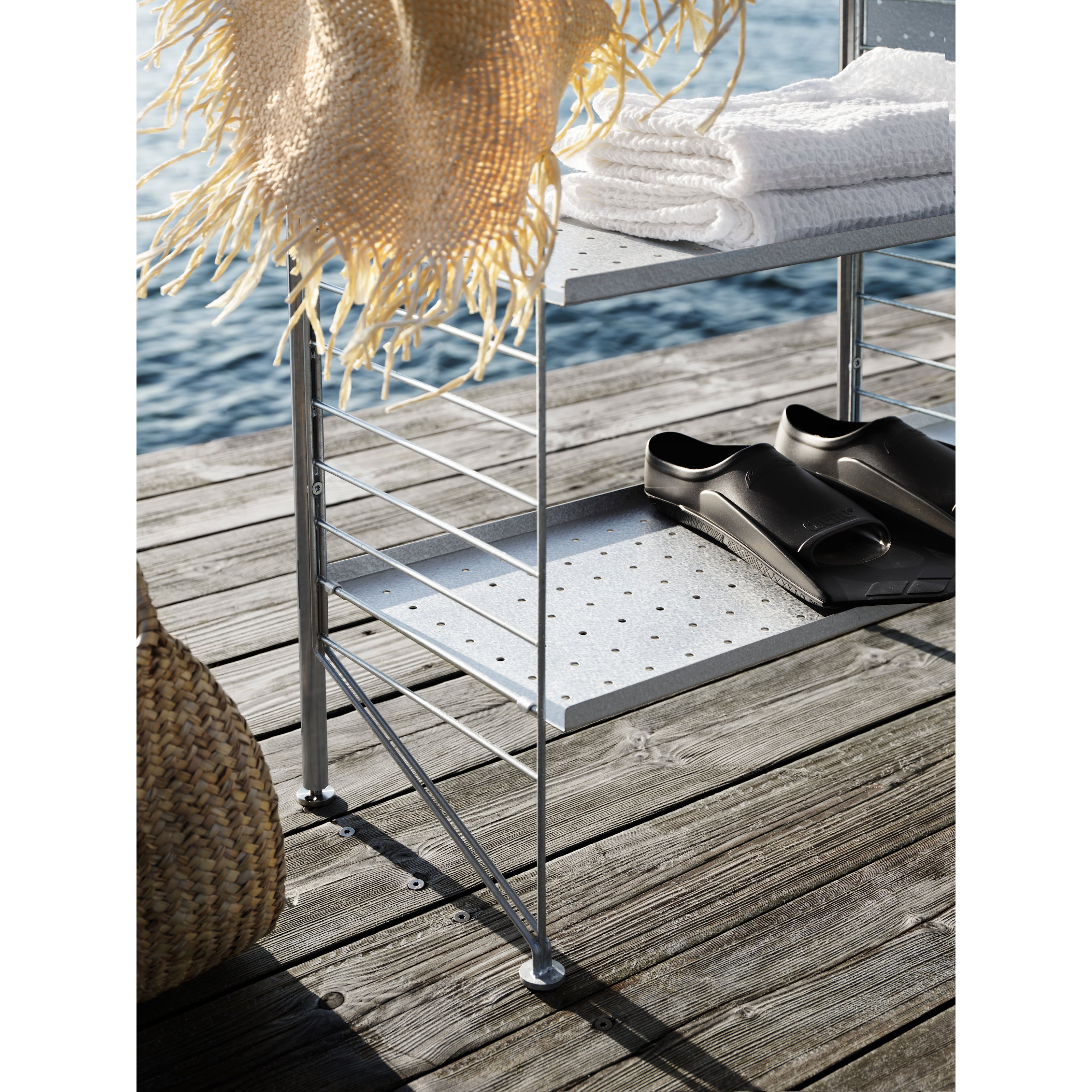 The free standing shelf intended for outdoor use from String® System fits equally well on a smaller balcony as on a larger terrace. The shelf is completely free standing but, if desired, can be secured to the base it is standing on. A complete section of the free standing shelf consists of one back panel, two uprights and two galvanized floor panels with height 85 cm and depth 30 cm. To build additional sections, you need one upright along with one panel for each section. We recommend at least one back panel, preferably placed in the middle, for a free standing shelf consisting of three sections. Add hooks to increase the storage possibilities. One section has the dimensions: width 61 cm and height 87 cm.