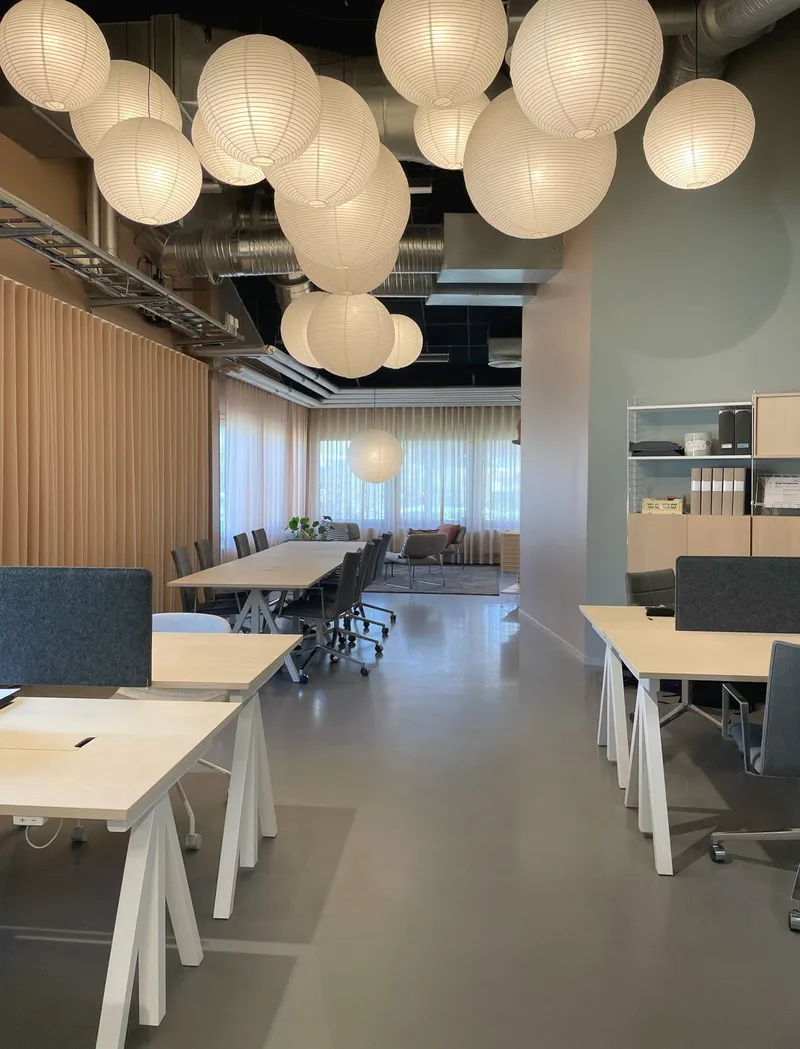 Height-adjustable work desks in ash / Floor panels in white, metal shelves with low edge in white and filing cabinets in ash